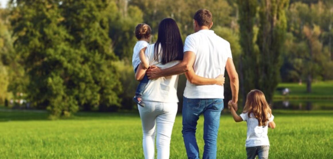 Rear view. Happy family with children walking in the park.