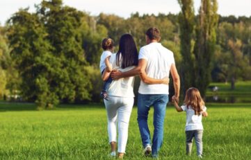 Rear view. Happy family with children walking in the park.