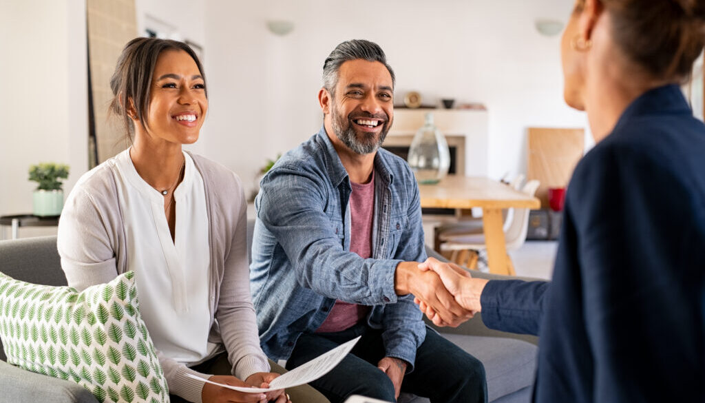 Multiethnic couple handshake with consultant at home